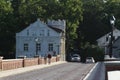 Old brick and stone bridge over small river near old city with ancient houses. Royalty Free Stock Photo