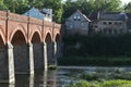 Old brick and stone bridge over small river near old city with ancient houses. Royalty Free Stock Photo