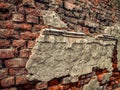 Ruins with remains of stucco on old brick wall.