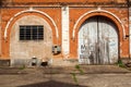 Old brick wall with closed white gates Royalty Free Stock Photo
