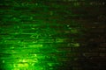 Old brick wall with emerald green neon lighting effect as background texture Royalty Free Stock Photo