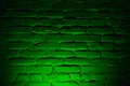 Old brick wall with emerald green neon lighting effect as background texture Royalty Free Stock Photo