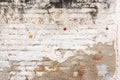 Old brick wall facade texture with white paint peeling off the surface Royalty Free Stock Photo