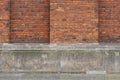 Old brick wall with a fluted stone base