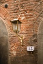 Old brick wall with 13 house number on it. And modern energy saving lamp in antique street lamp on retro wall Royalty Free Stock Photo