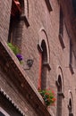 Old brick wall with lantern and flower decoration, detail in downtown of Ferrara, Italy