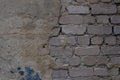 An old brick wall made of white brick, with crumbling plaster.