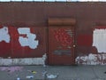 Old brick Wall with metallic roller shutter door. Abandoned industrial area