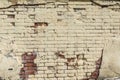 An old brick wall painted yellow with worn paint and no cement plaster. Vector cement and brick texture background Royalty Free Stock Photo