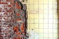 Old brick wall with peeling plaster, grunge background and old chipped tiles. Royalty Free Stock Photo