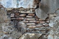 an old brick wall that is porous and eroding until the bricks are visible because the cement is peeling off Royalty Free Stock Photo