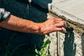 An old bricklayer lays out concrete tiles outside on a summer day.