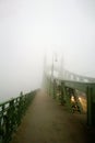 Old bridge in the fog. Mystical vision. A couple of people walk together in the fog.