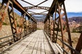 Old bridge made of wood and iron in a path in the mountains