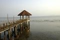 Old bridge made from wooden plank walk way to building red roof on black sand beach at thailand. Thai destination to travel in koh Royalty Free Stock Photo