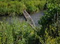 An old  bridge of wooden planks across a small river Royalty Free Stock Photo