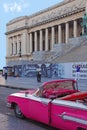 Old Bright Pink convertible classic vintage Cuban yank tank Car in front of National Capitol Building, Havana, Cuba