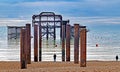 A view along the rusting pillars of The Old Brighton Pier on a bright calm day. Royalty Free Stock Photo