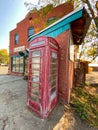 Old british english telephone phone box booth in front of a deserted hotel in a rundown ghost town Royalty Free Stock Photo