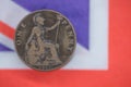 Old British penny coin with out of focus Union Flag to background.