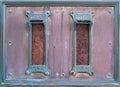 Old british postal mail boxes with rusted letter slots and ornate green copper frames