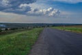 Old broken asphault road in green field over blue sky Royalty Free Stock Photo