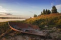 Old broken boat on the shore of the lake at sunset. Arkhangelsk Royalty Free Stock Photo