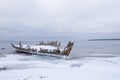 Old broken boat wreck and rocky beach in wintertime. Royalty Free Stock Photo