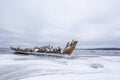 Old broken boat wreck and rocky beach in wintertime. Royalty Free Stock Photo