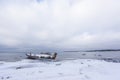 Old broken boat wreck and rocky beach in wintertime. Royalty Free Stock Photo
