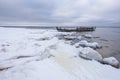 Old broken boat wreck and rocky beach in wintertime. Royalty Free Stock Photo