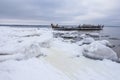 Old broken boat wreck and rocky beach in wintertime. Royalty Free Stock Photo