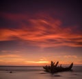 Old broken boat wreck on the shore, a frozen sea and beautiful blue sunset background. Royalty Free Stock Photo