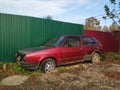 Old broken car. abandoned rusty car at the fence in the yard