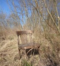 Old broken chair stands in the stale grass, loneliness, old age concept Royalty Free Stock Photo