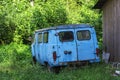 An old broken down abandoned car of blue color standing among the greenery Royalty Free Stock Photo