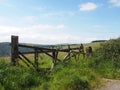 old broken down wooden gate in front of a grass covered meadow surrounded by hills and fields near hebden bridge in calderdale Royalty Free Stock Photo