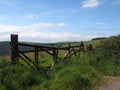 Old broken down wooden gate in front of a grass covered meadow surrounded by hills and fields near hebden bridge in calderdale Royalty Free Stock Photo