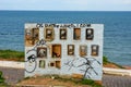 Old and broken electric meter boxes on a wall in front of the sea