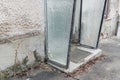 Old broken entrance area of a front door with glass walls and glass roofing, Germany