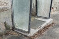 Old broken entrance area of a front door with glass walls and glass roofing, Germany