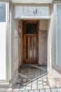 Old broken entrance area of a front door with glass walls and glass roofing, Germany