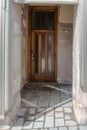 Old broken entrance area of a front door with glass walls and glass roofing, Germany