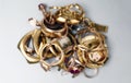 Old and broken gold and silver jewelry, coins, watches of gold, and gold-plated lie in a pile.