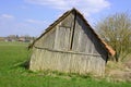 Old broken hut partly sunk into the wet soil, wetland hut in bad state Royalty Free Stock Photo