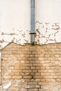 Old broken rain water pipe with a damaged wall Royalty Free Stock Photo