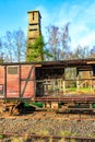 Old broken red wooden freight car on disused train tracks at old station