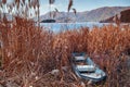 Old broken row boat stuck on land overgrown with grass at lake shore Royalty Free Stock Photo