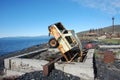 Old broken rusty abandoned car upside down at sea coast Royalty Free Stock Photo