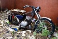 Old, broken and rusty motorcycle at an empty lot Royalty Free Stock Photo